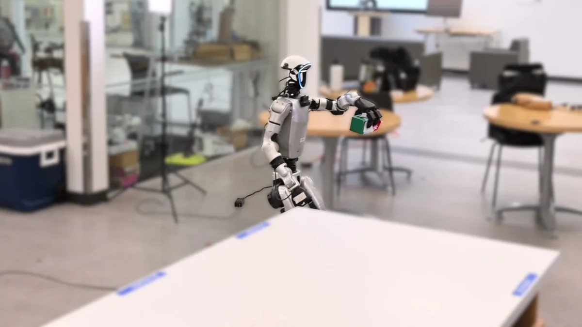 HomeBody humanoid carries a small object across a kitchen test space in the research team’s demonstration video