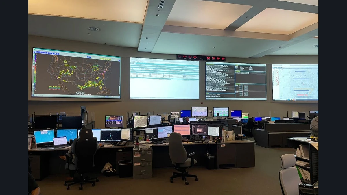 FAA Command Center in Warrenton, Virginia, with air-traffic maps and system displays above rows of workstations.