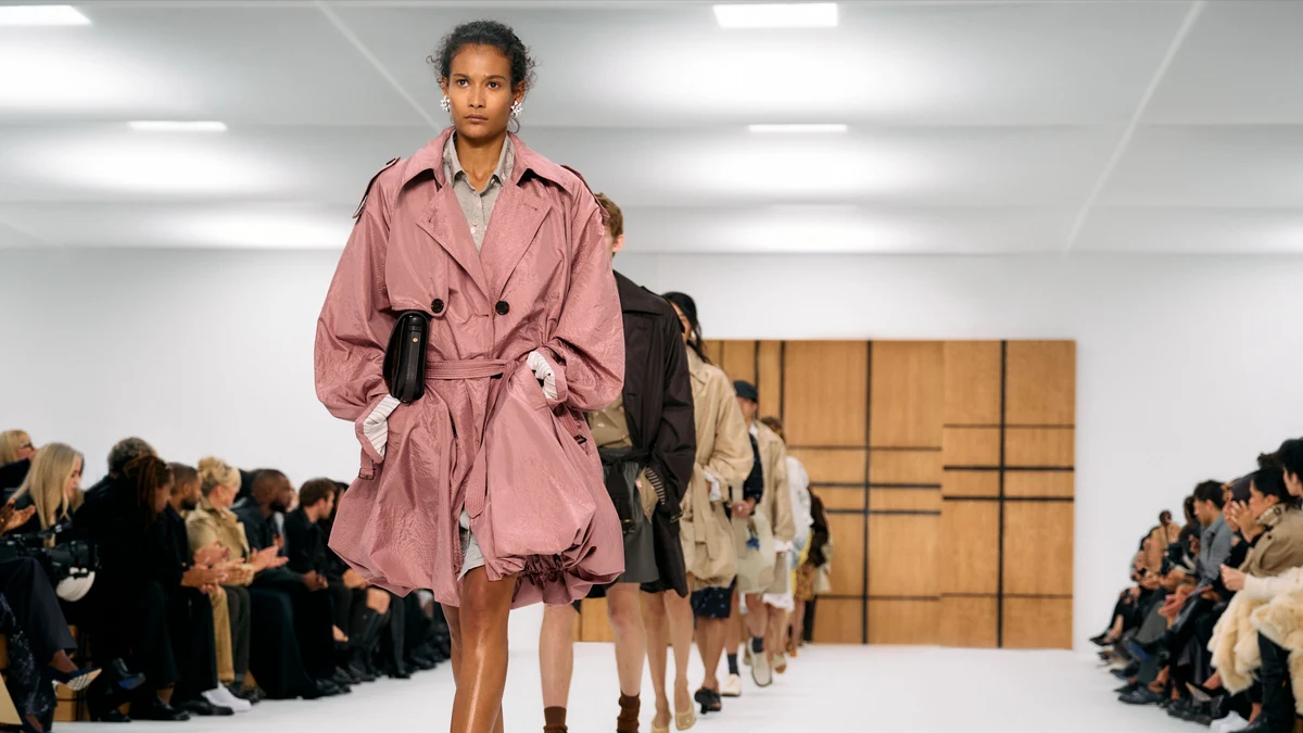 A model walks the Burberry Spring 2027 runway in a pale pink trench with gathered bubble volume and expanded sleeves.