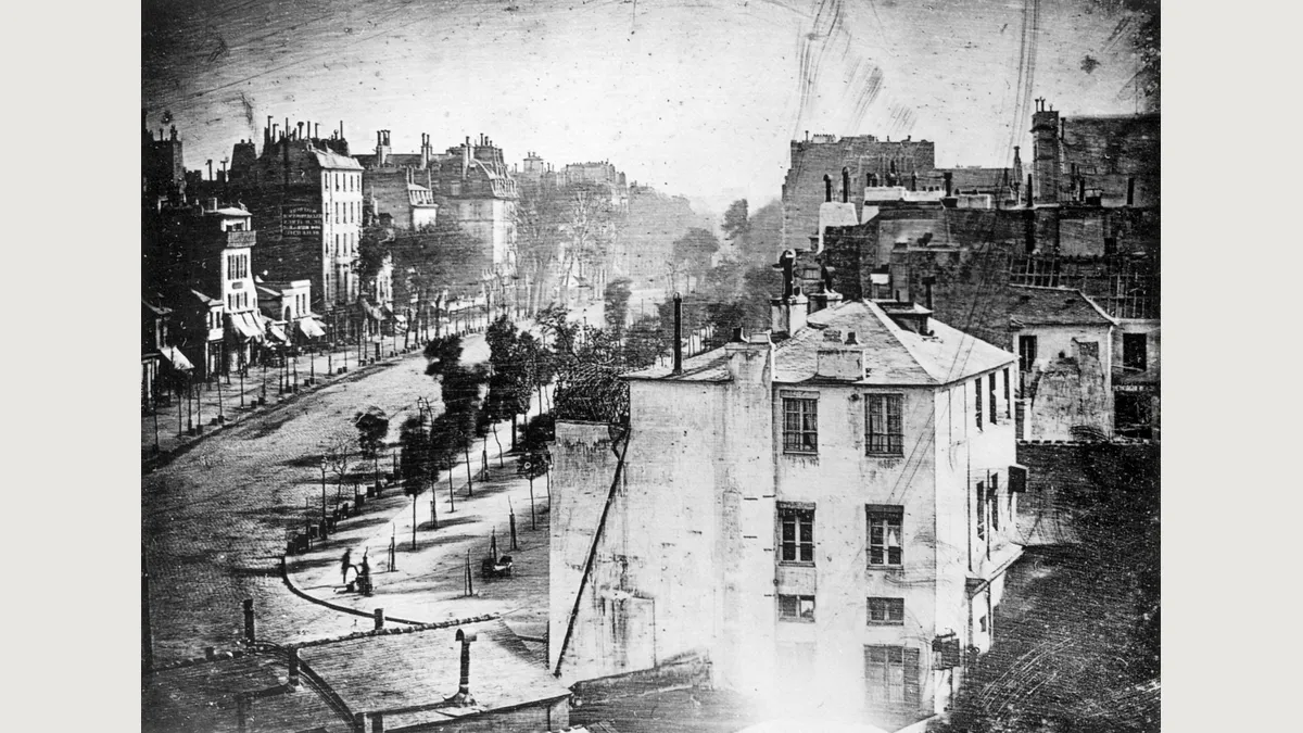 Daguerre’s mirrored view of Boulevard du Temple, with a shoeshine client and worker near the lower left.
