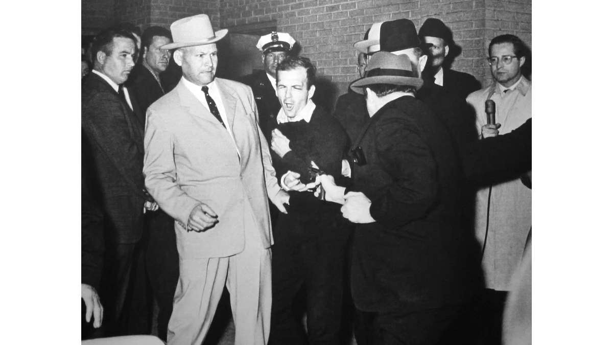 Bob Jackson’s black-and-white photograph shows Jack Ruby aiming at Lee Harvey Oswald as Oswald recoils beside Detective Jim Leavelle in the Dallas police basement.