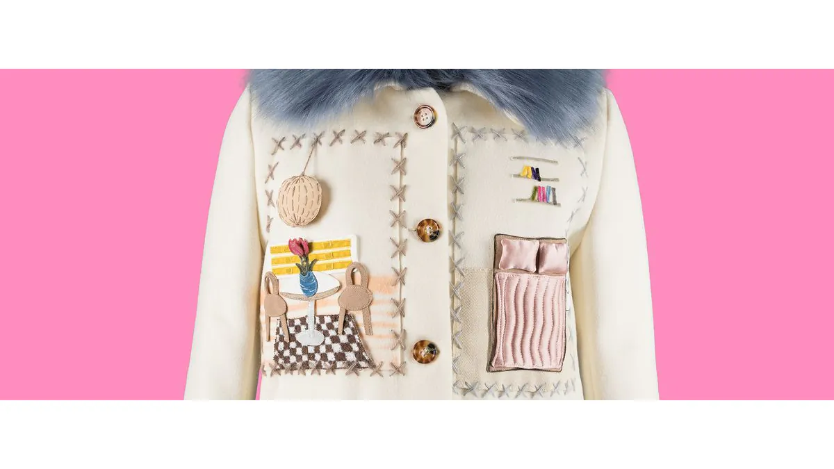 Detail of Lirika Matoshi’s cream Apartment Coat with blue faux fur collar and appliquéd dollhouse rooms, photographed by Eileen Costa for The Museum at FIT