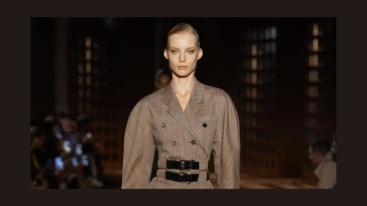 Model in a gray Ferragamo Spring 2027 tailored dress with two black belts on the Milan runway