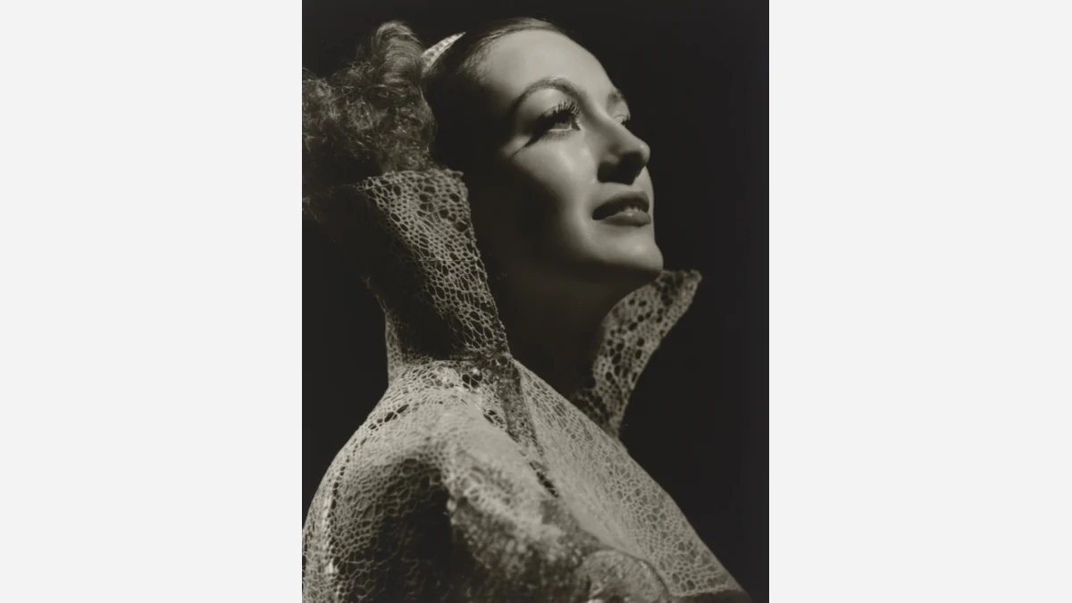 George Hurrell’s portrait of Joan Crawford, circa 1935, with her face turned upward above a lace collar.