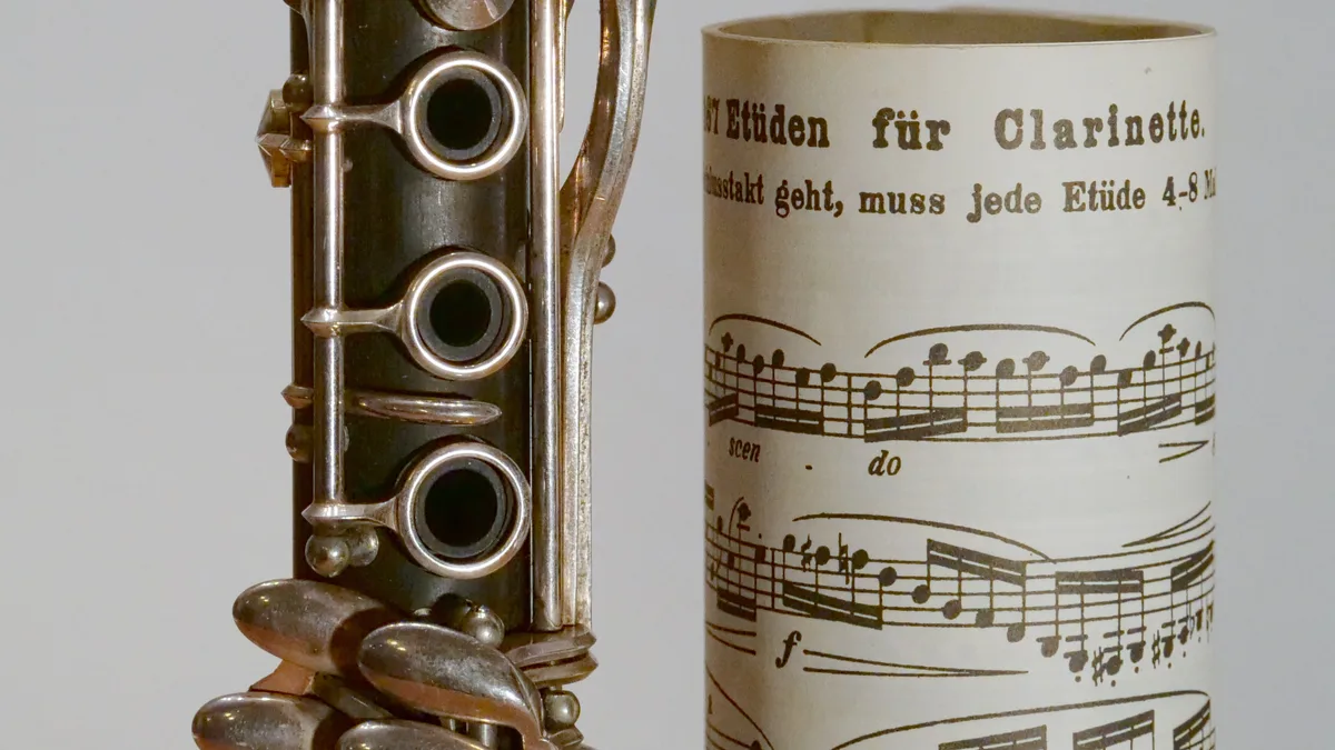 Cropped ISO 6400 Panasonic GH5S test photograph showing clarinet keys and printed music against a smooth gray background