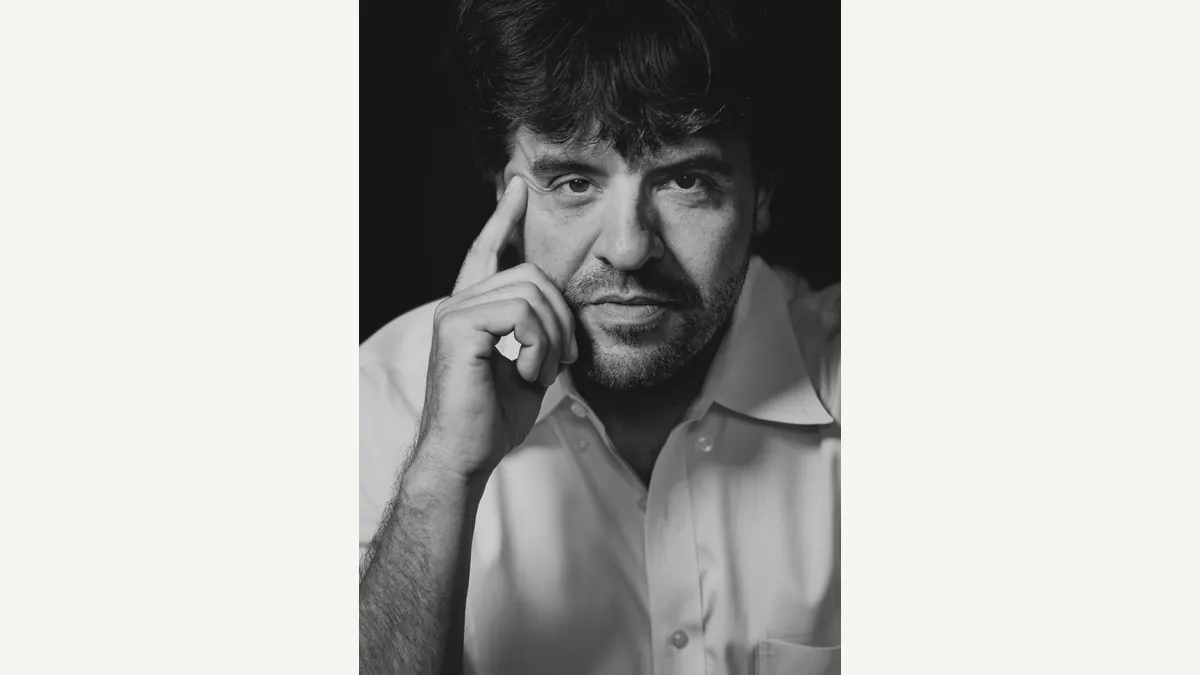 Christopher P. Michel’s 2022 black-and-white portrait shows Karl Deisseroth looking toward the camera with one hand near his temple
