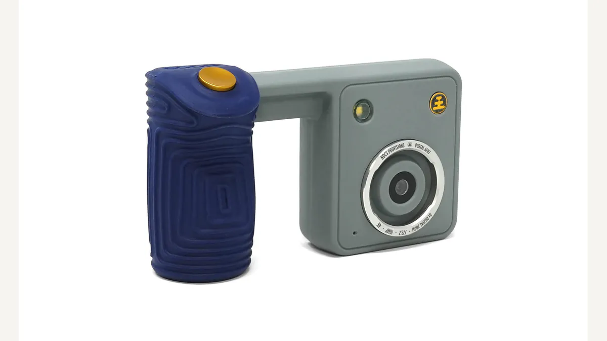 Nocs Provisions’ official Portal AFN7 product illustration shows the gray camera, its blue grip, yellow shutter button, and front lens assembly at an angle