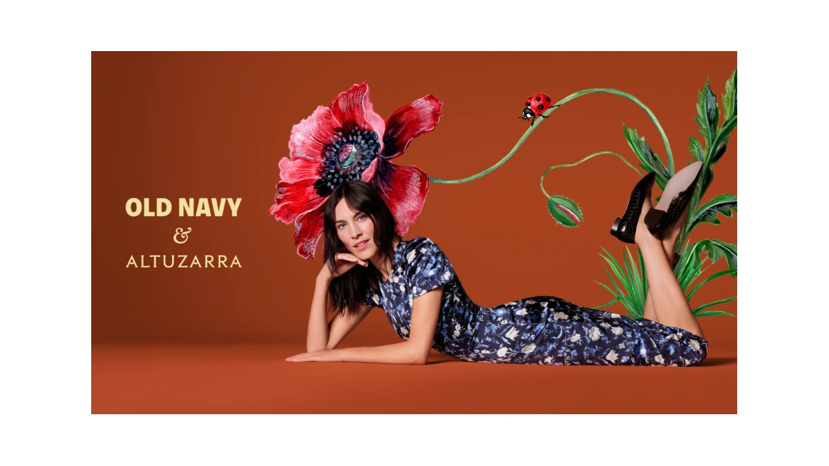 Alexa Chung wears a blue floral Old Navy x Altuzarra dress in the official campaign against a rust-colored floral backdrop