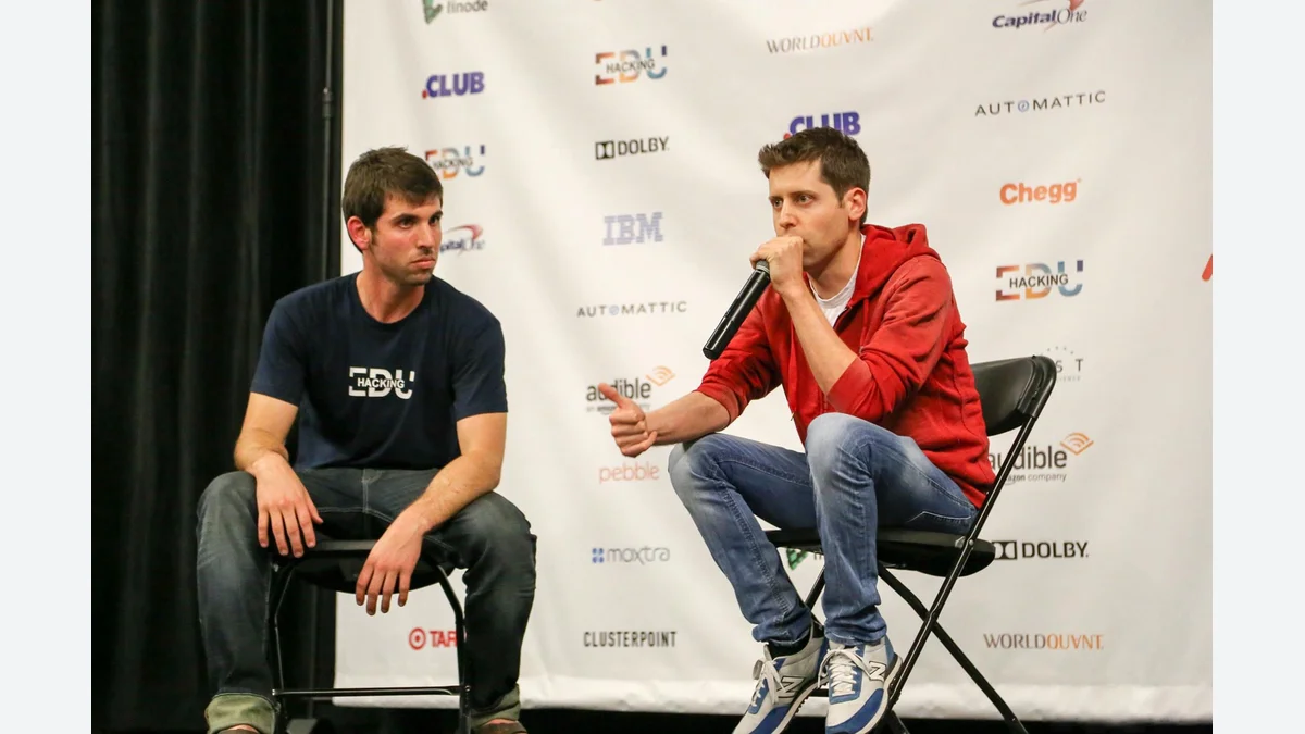 Sam Altman, right, holding a microphone beside Alex Cory during a fireside chat in 2016.